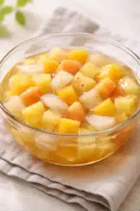 fruit cocktail gelatin cups Poached fruit cooling in vanilla syrup